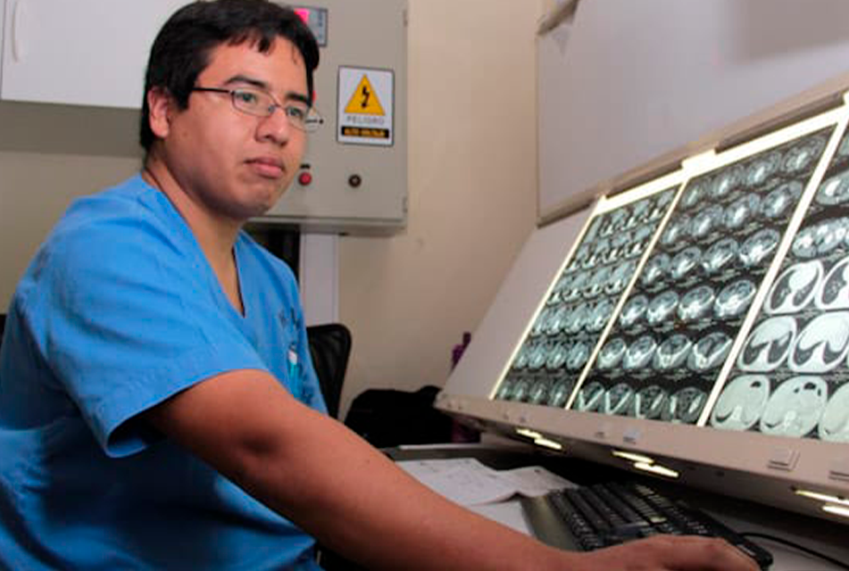 Profesional de salud revisando imágenes diagnósticas; fotografía referencial de atención especializada.